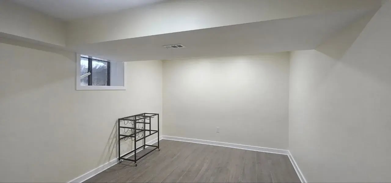 Finished basement room with window and new flooring
