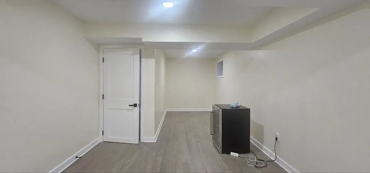 Finished basement hallway with white doors