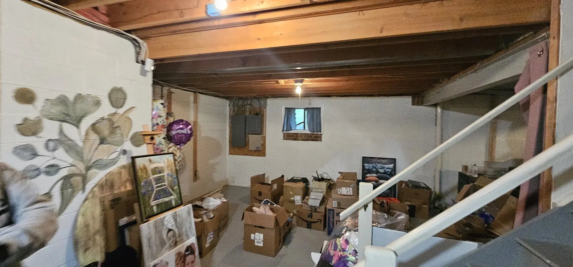 Unfinished basement with exposed ceiling and stored boxes
