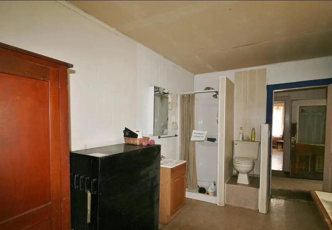 Dated bathroom with old shower stall and toilet before remodel