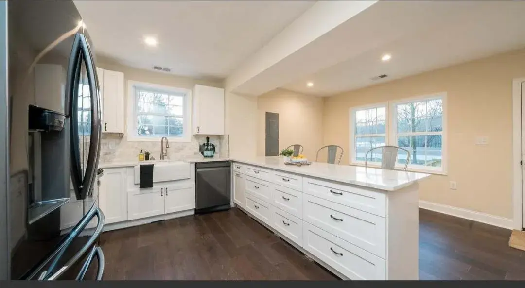 Updated kitchen with white peninsula, farmhouse sink and large windows