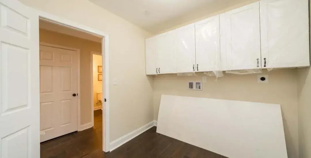 Laundry area with new white upper cabinets and fresh paint
