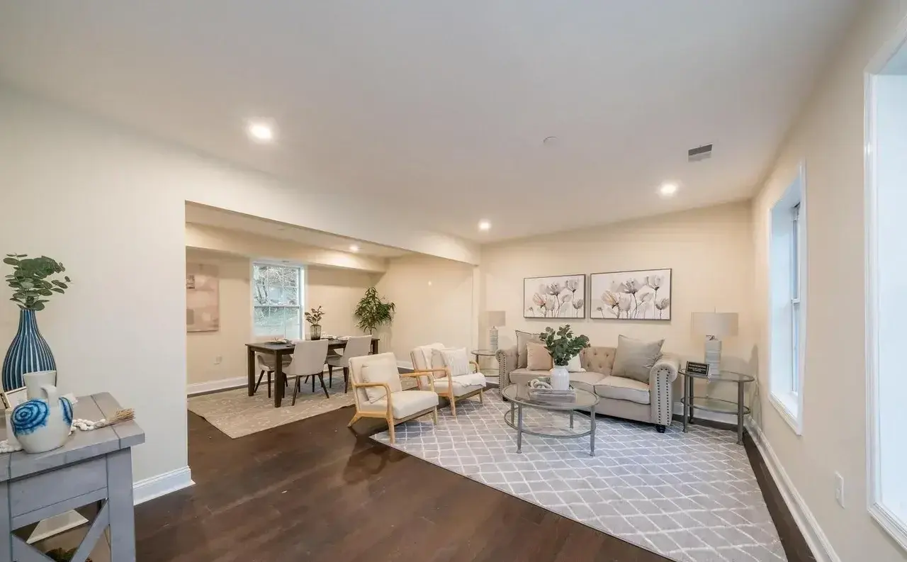 Spacious renovated living room with neutral walls and new wood flooring