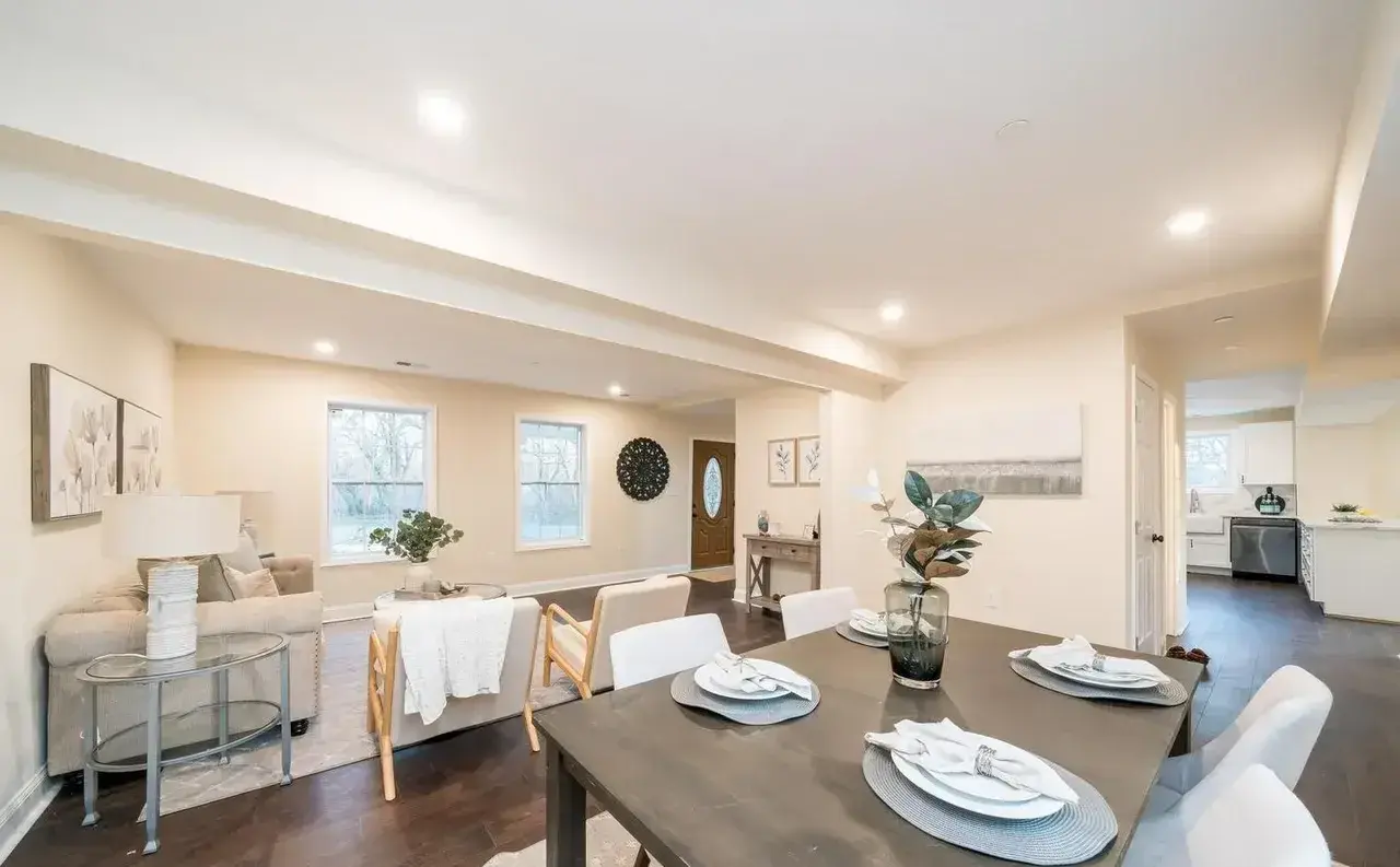 Open living and dining area with dark wood floors and recessed lights