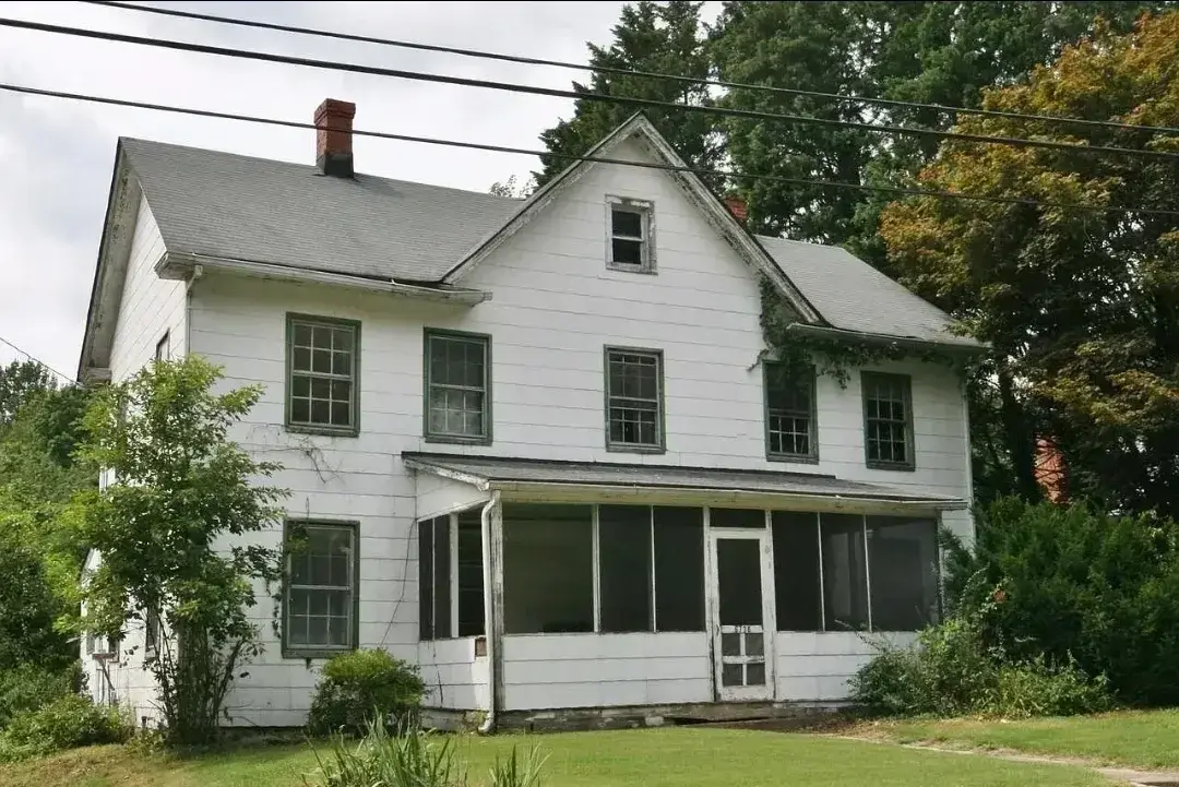 Old two-story farmhouse in Solomons, MD before renovation with screened porch