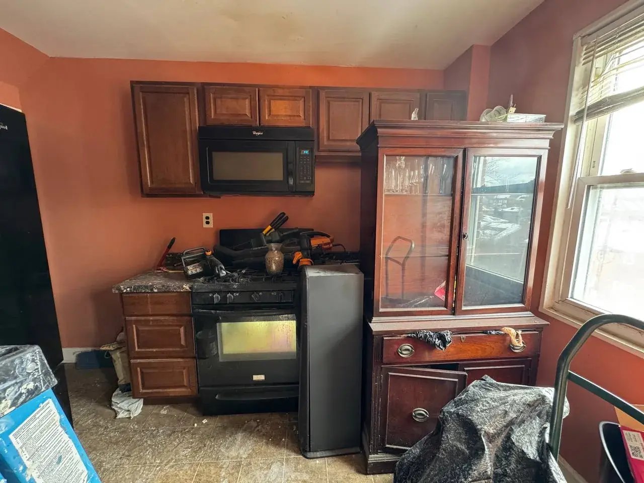 Dated kitchen with orange walls and dark cabinets before renovation