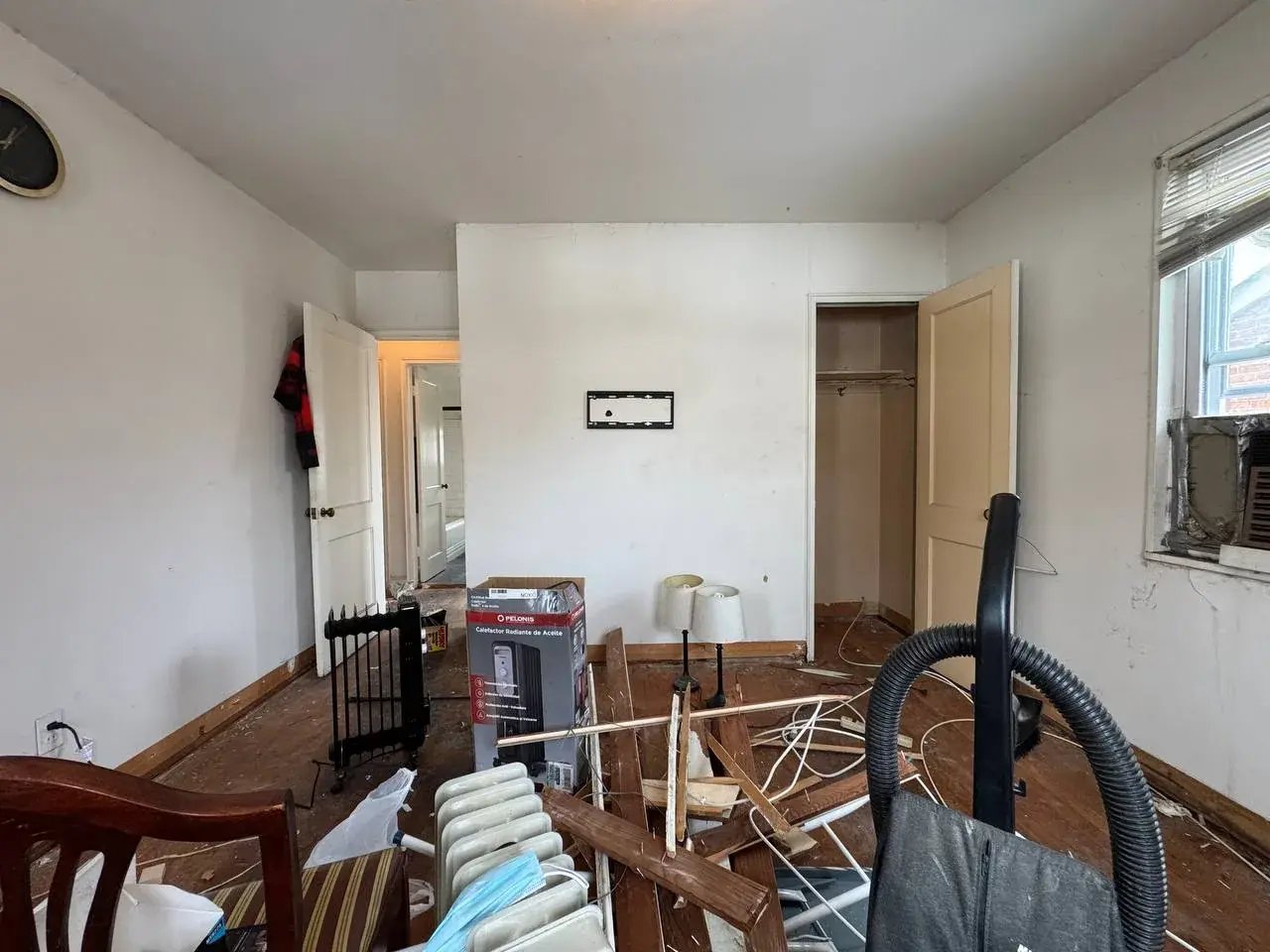 Living room full of furniture and debris before renovation