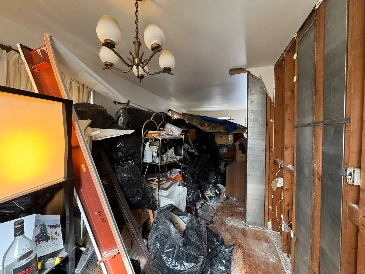 Dining area packed with belongings and trash before the cleanout