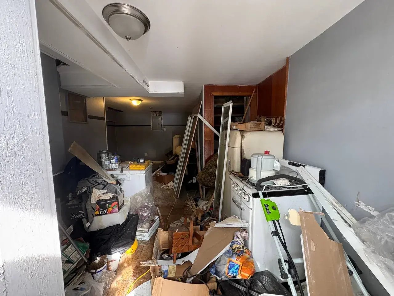 Basement filled with furniture and boxes before the cleanout
