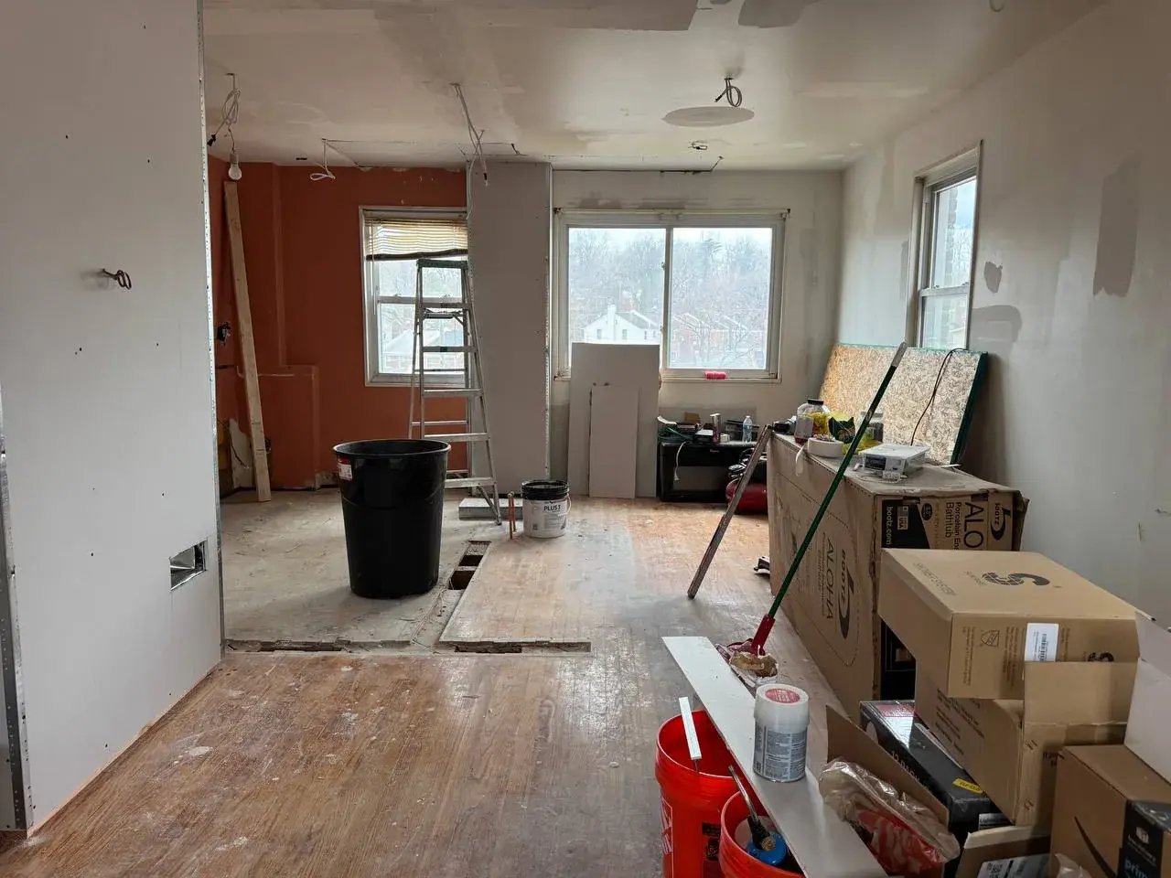 Open main level during drywall work, looking toward the kitchen