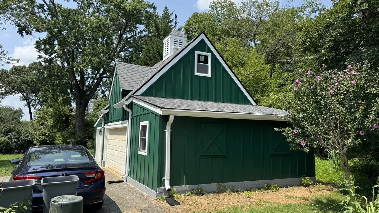 Renovated garage with green fiber cement siding and white trim