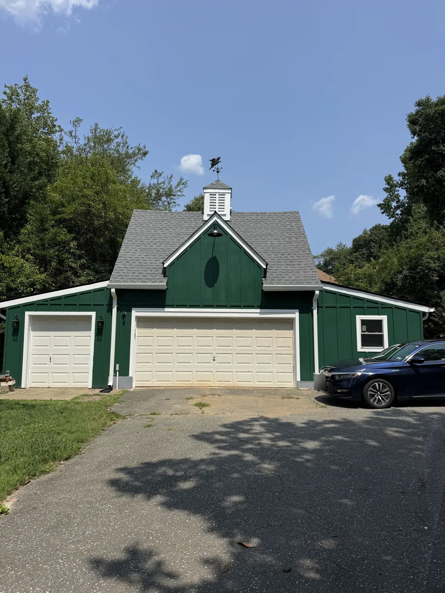 Renovated detached garage with green fiber cement siding, front view