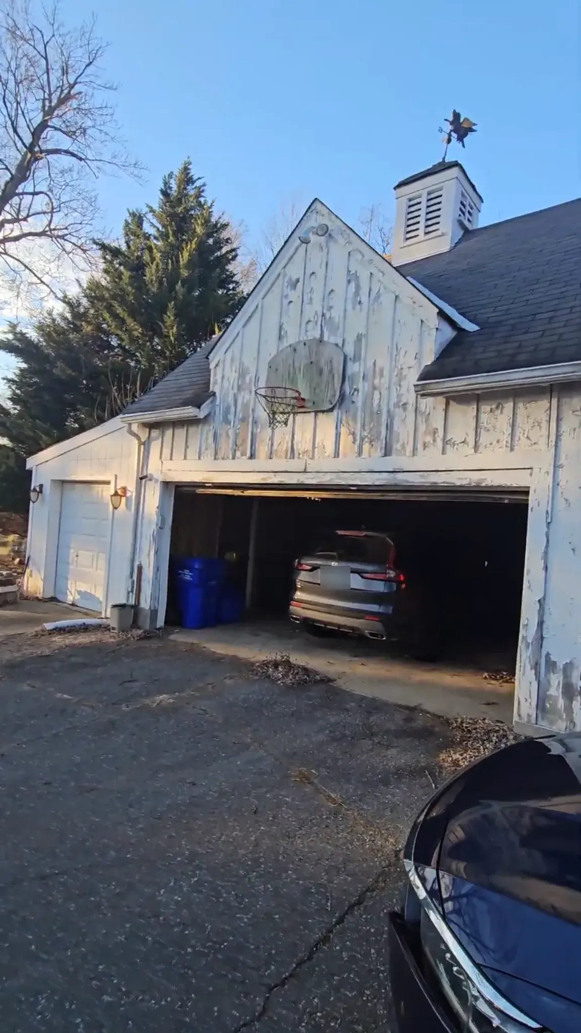 Old detached garage with peeling white siding, front view