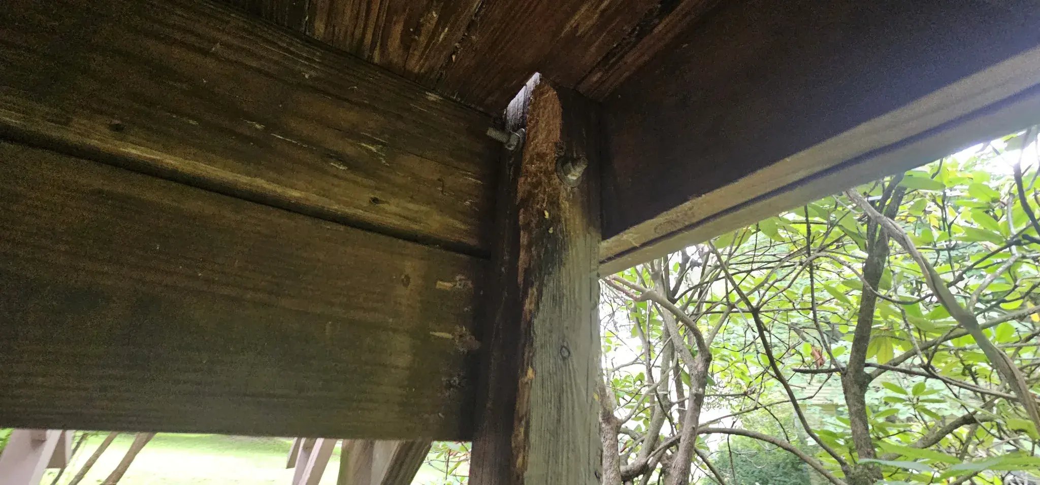 Weathered deck post and beam under the old deck