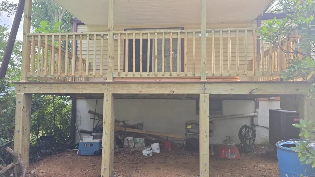 New deck with bare pressure-treated railings drying before paint