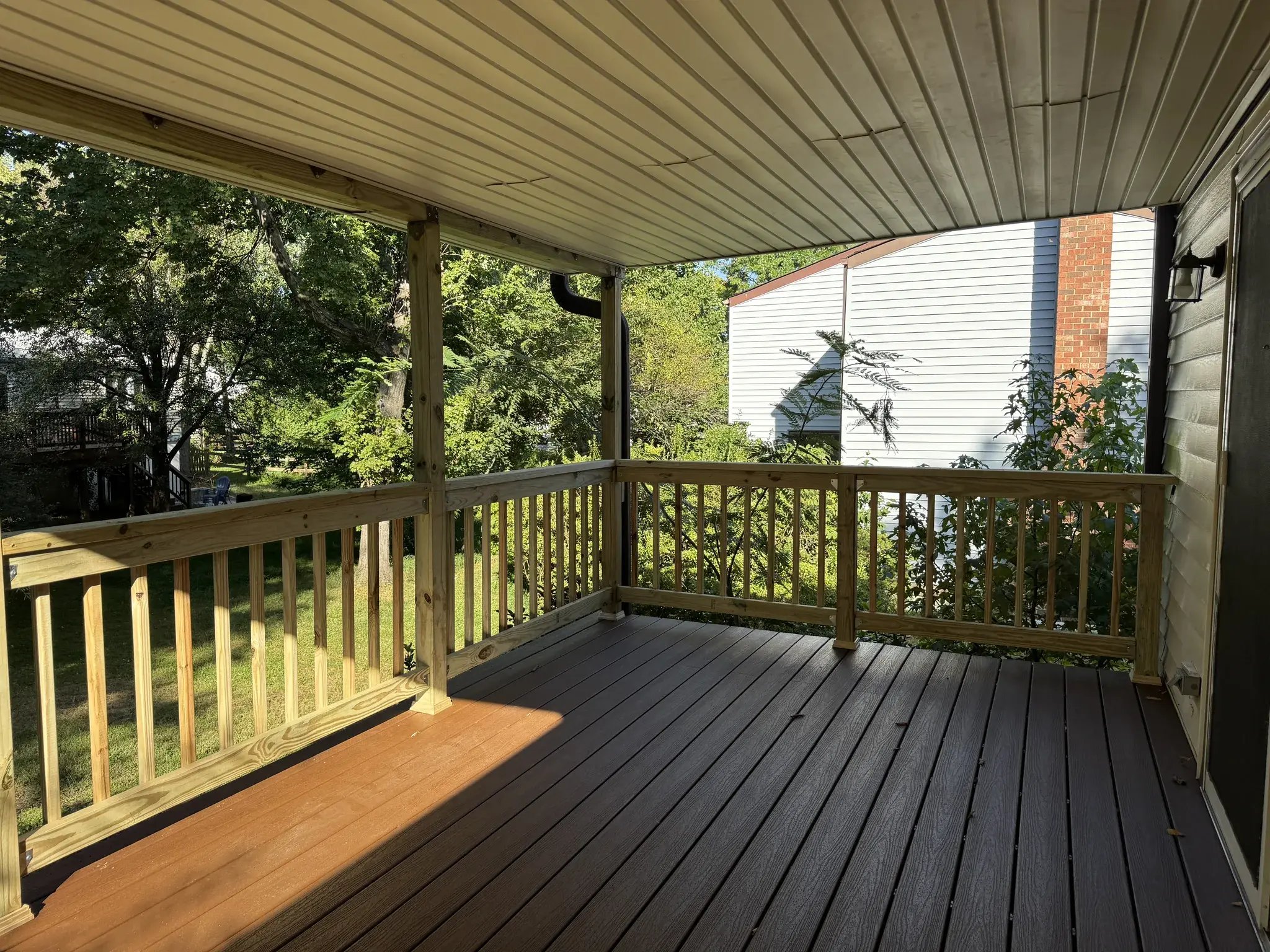 Composite decking and new railings on the covered deck in the sun
