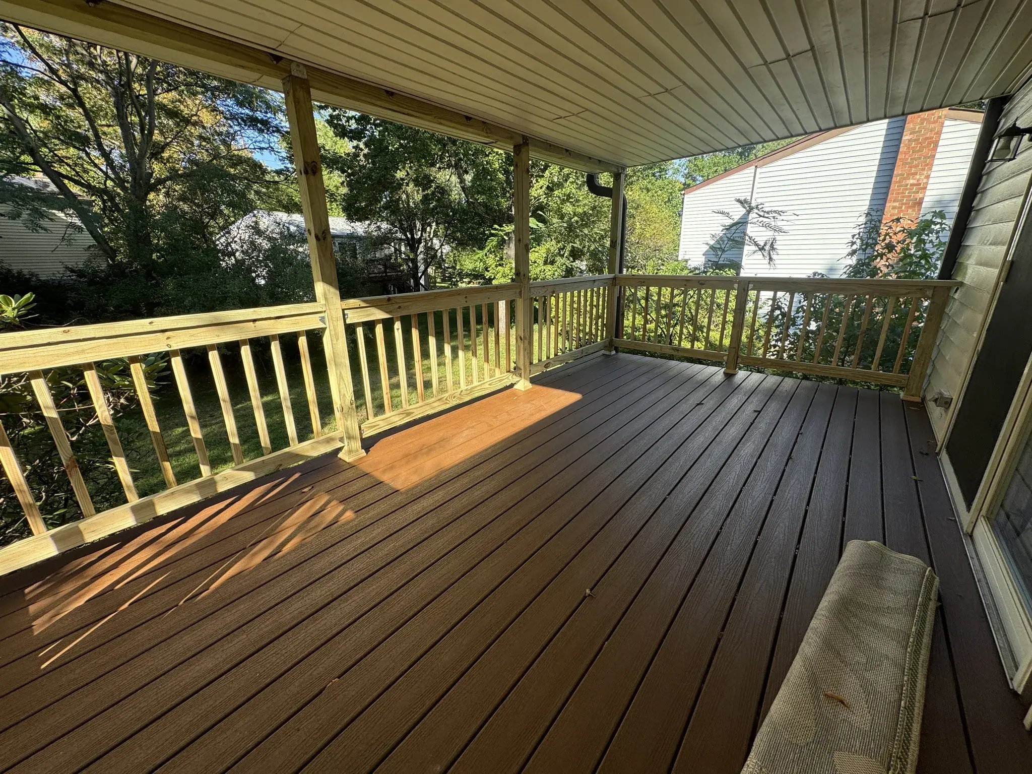Sunlit composite deck with new pressure-treated railings