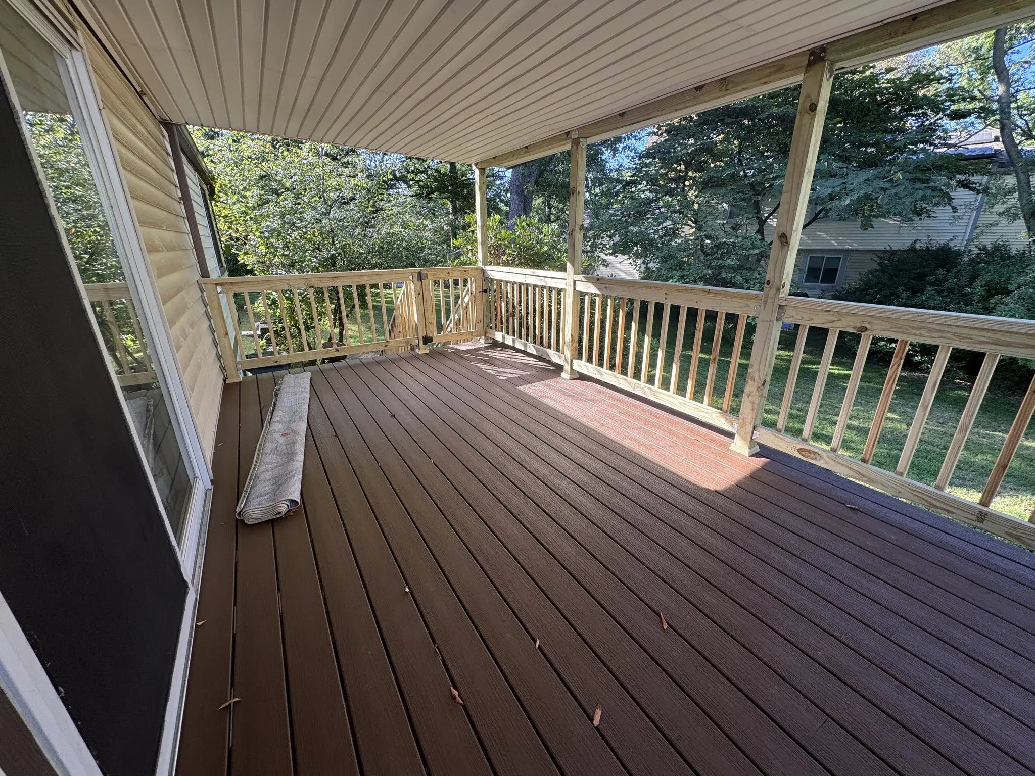 New covered deck with composite decking, view along the house