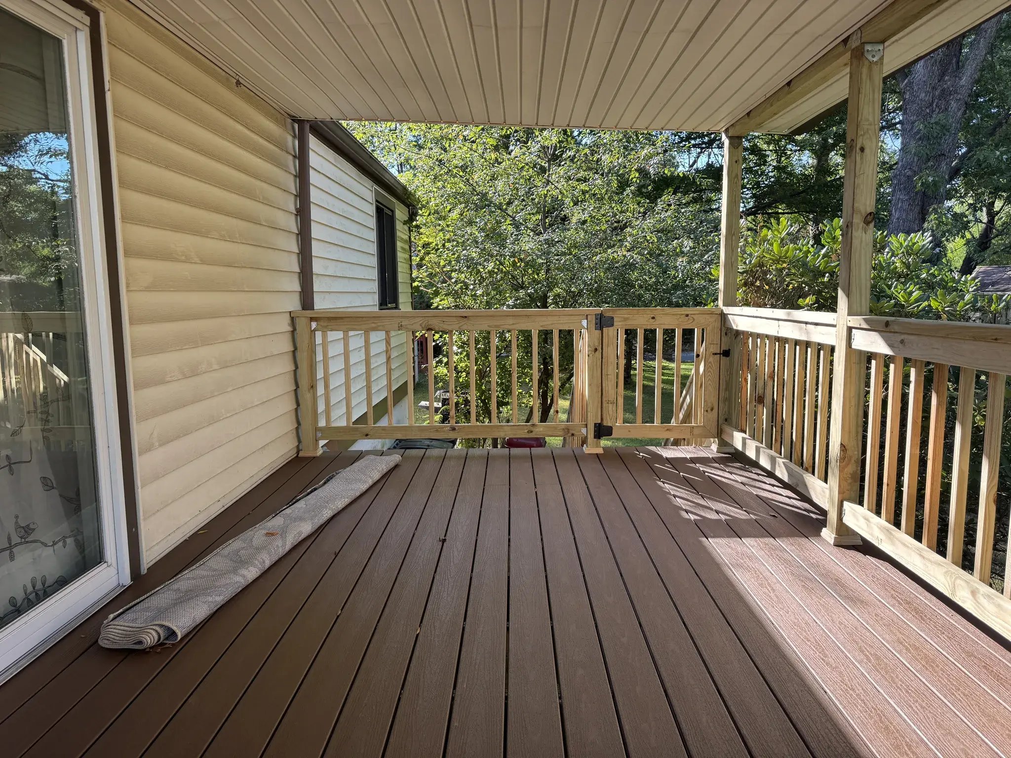 New composite decking and railings with a backyard view