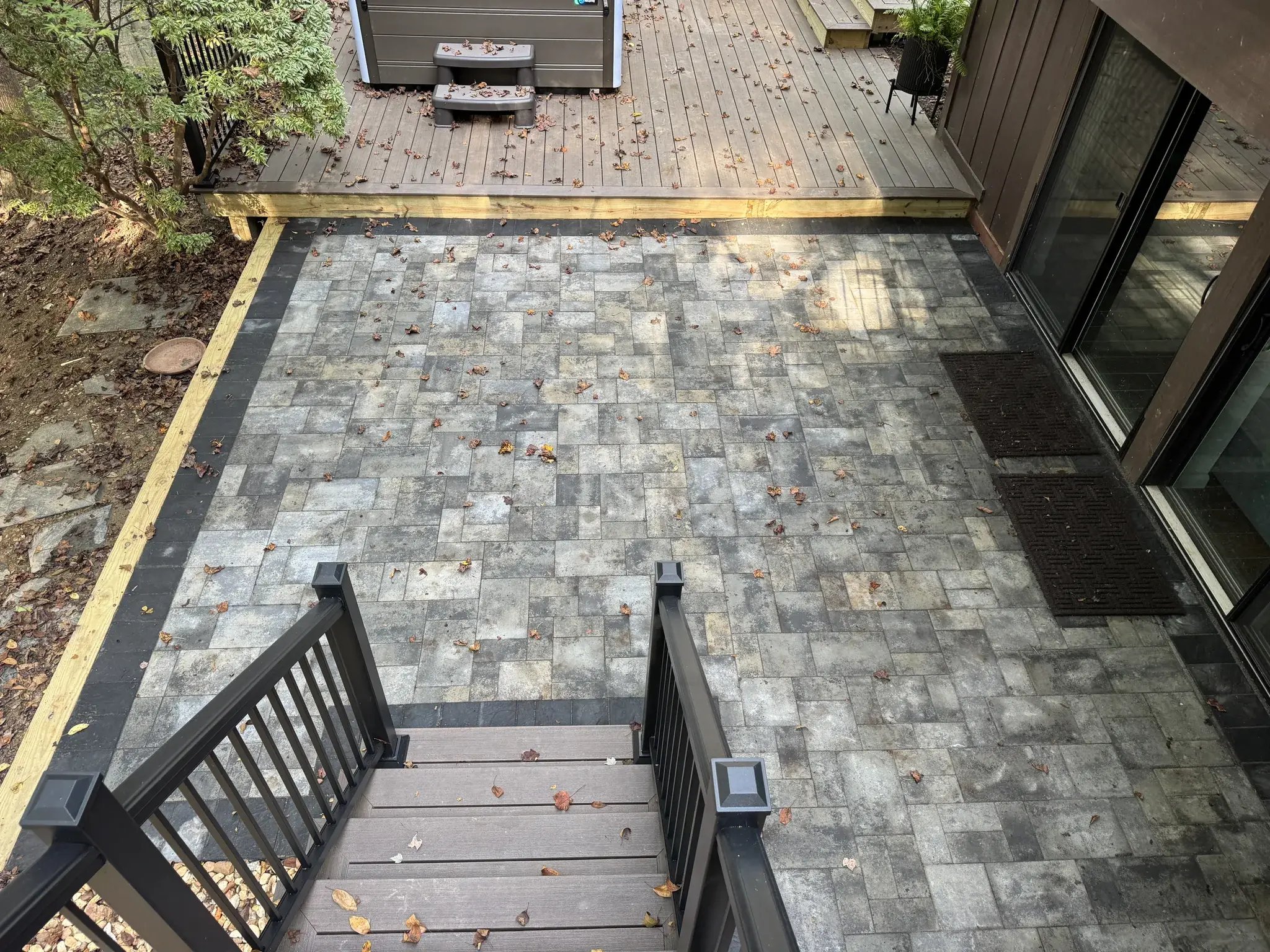 Paver patio with a dark border seen from the new stairs