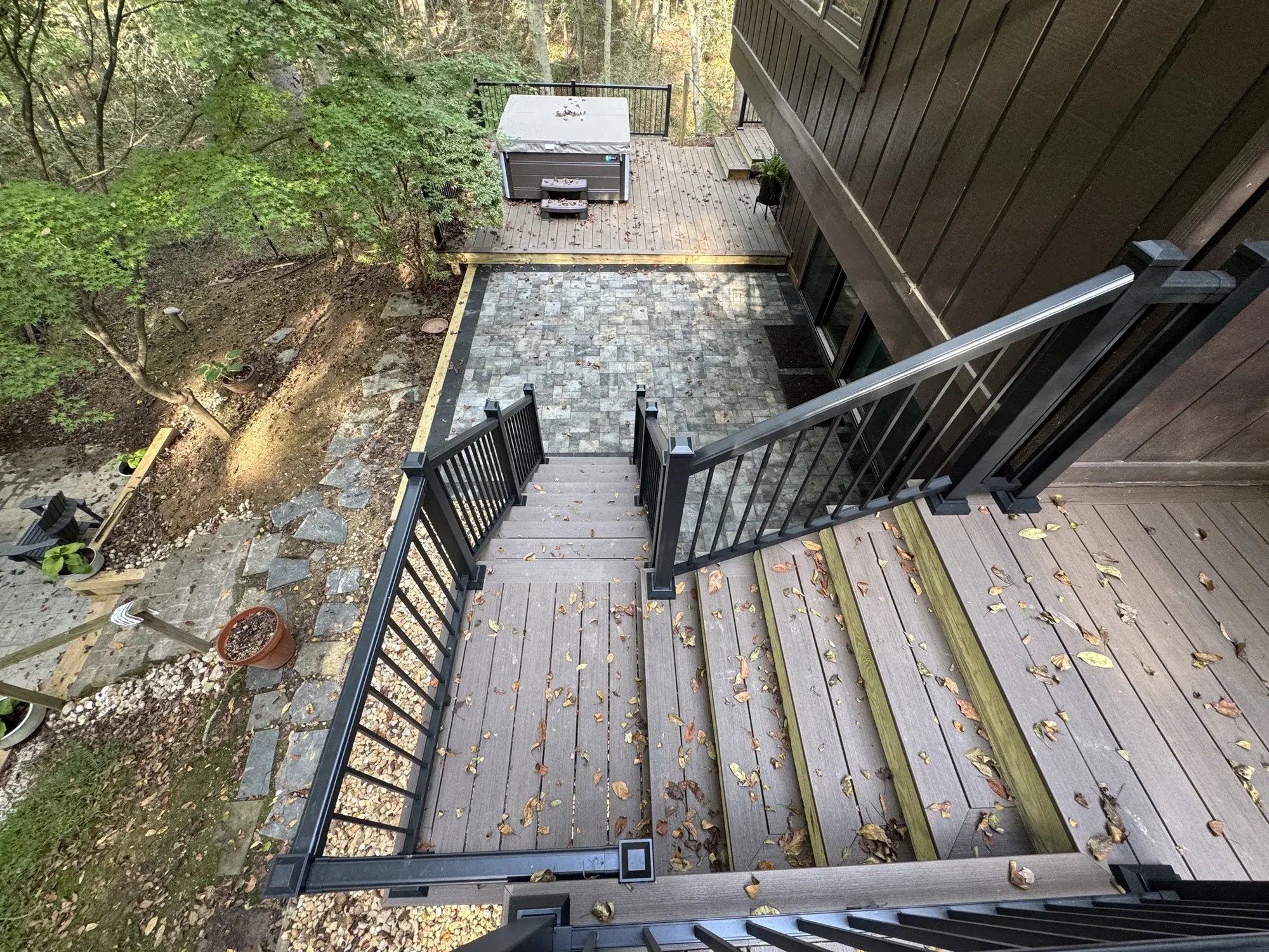 New composite stairs with black railings down to the patio