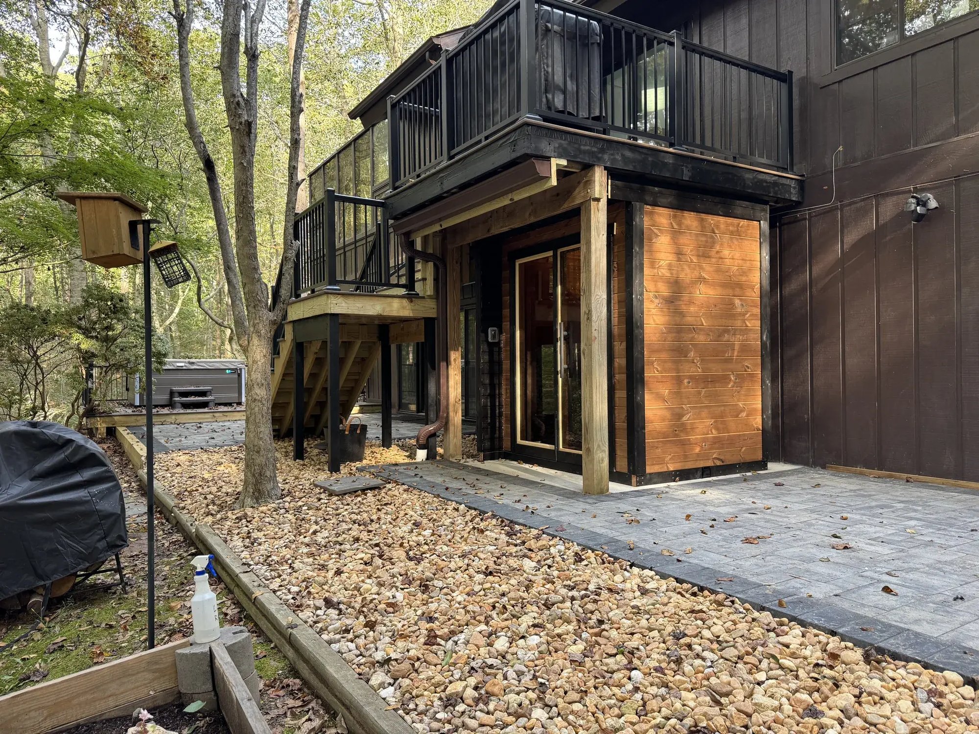 Outdoor sauna and paver patio under the upper deck