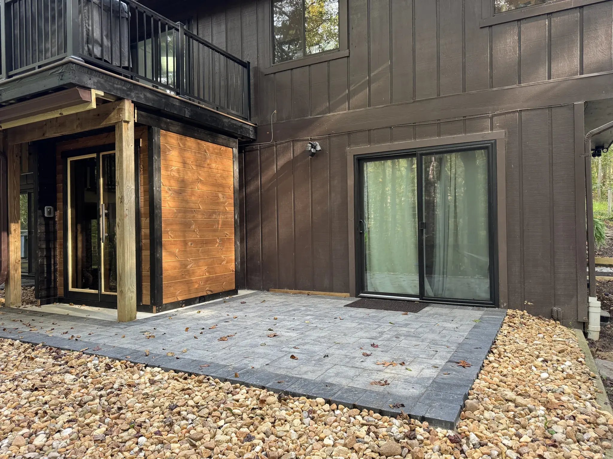 Paver patio next to the sauna and sliding doors