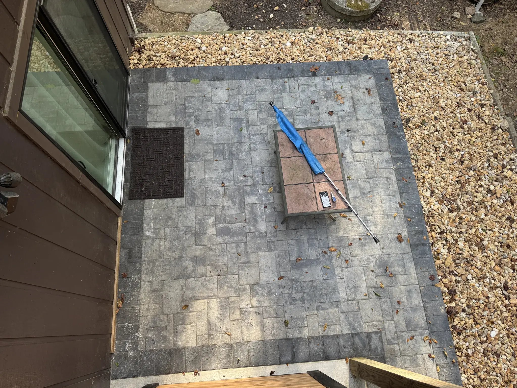 Small paver patio with a dark border along the house