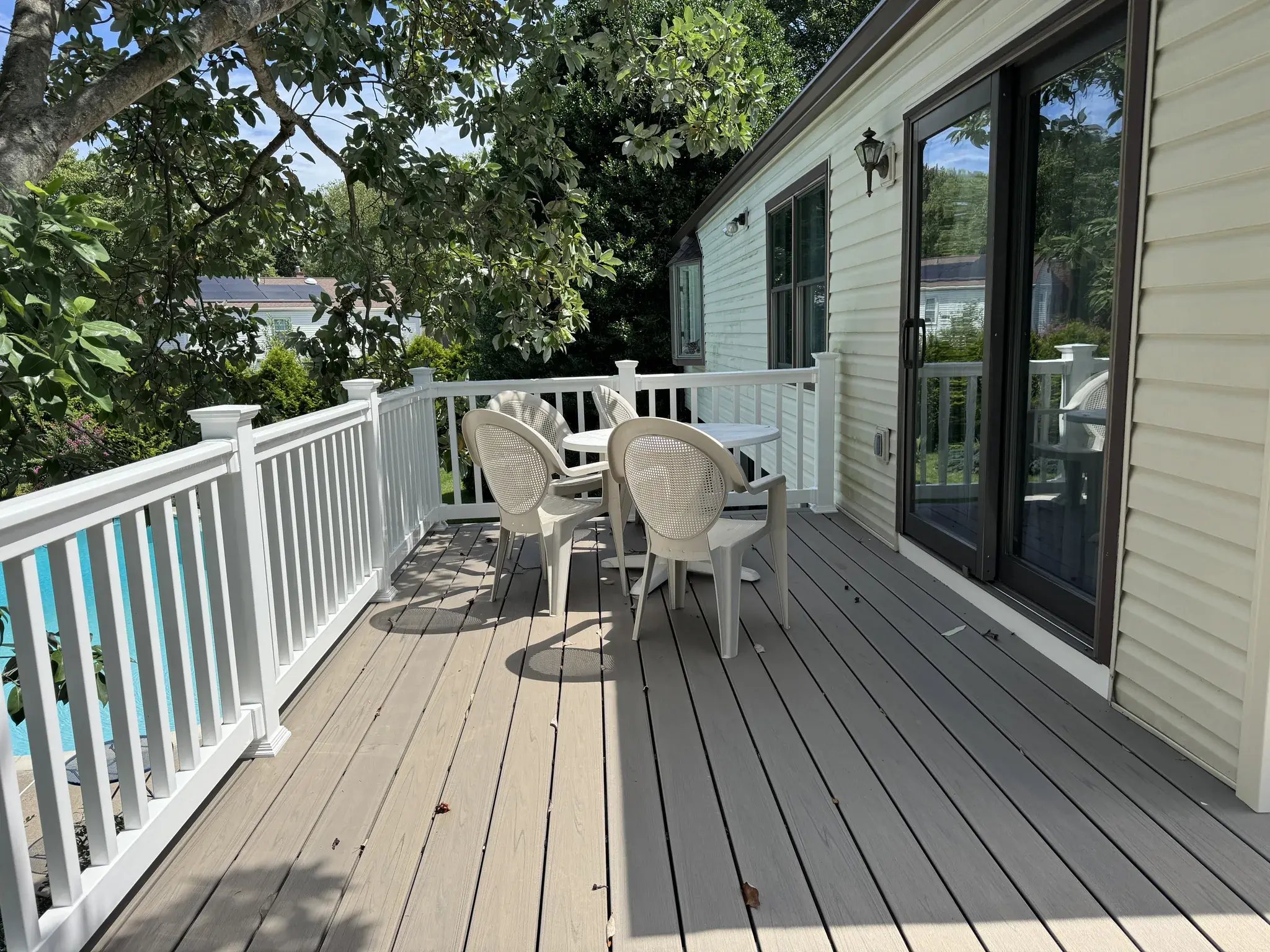 Deck along the house with new railings and patio furniture