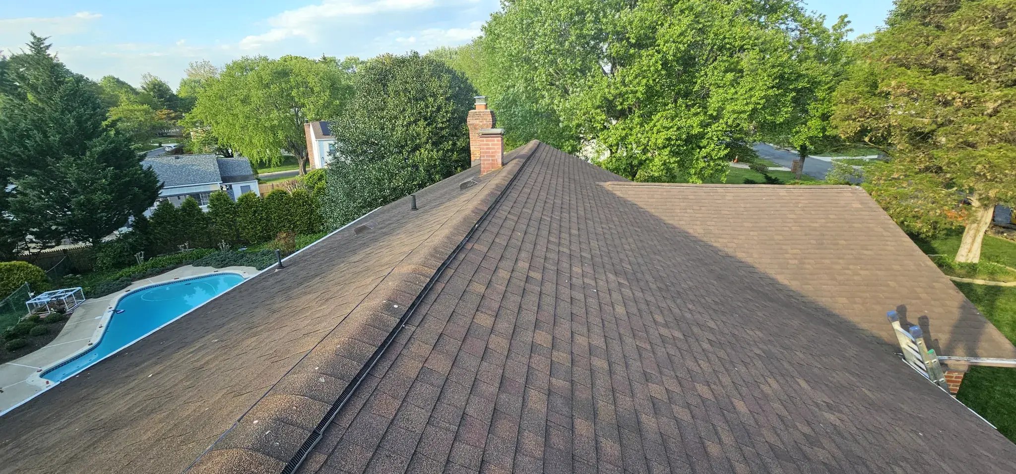 Old roof shingles before replacement, view toward the pool