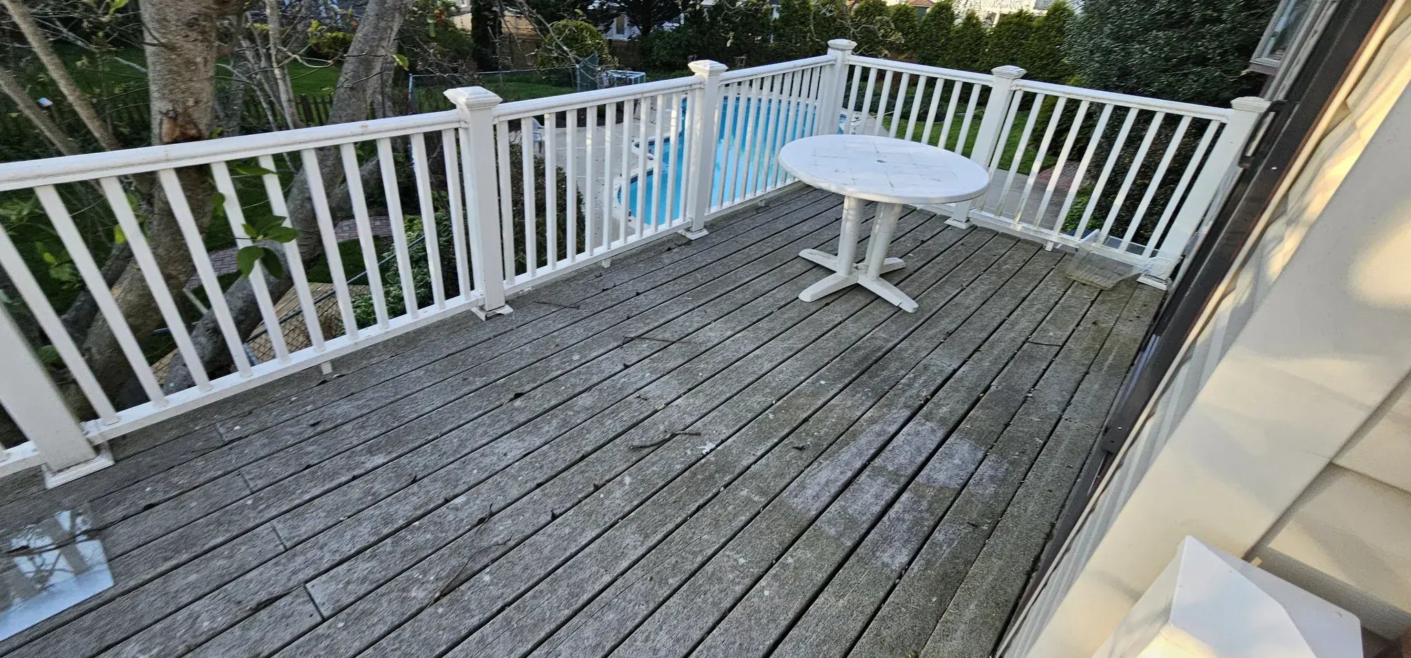 Old wood deck with weathered boards and vinyl railings