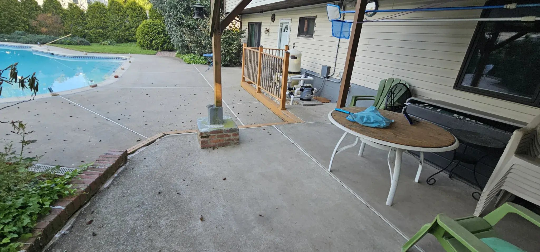 Back patio and old deck posts next to the pool