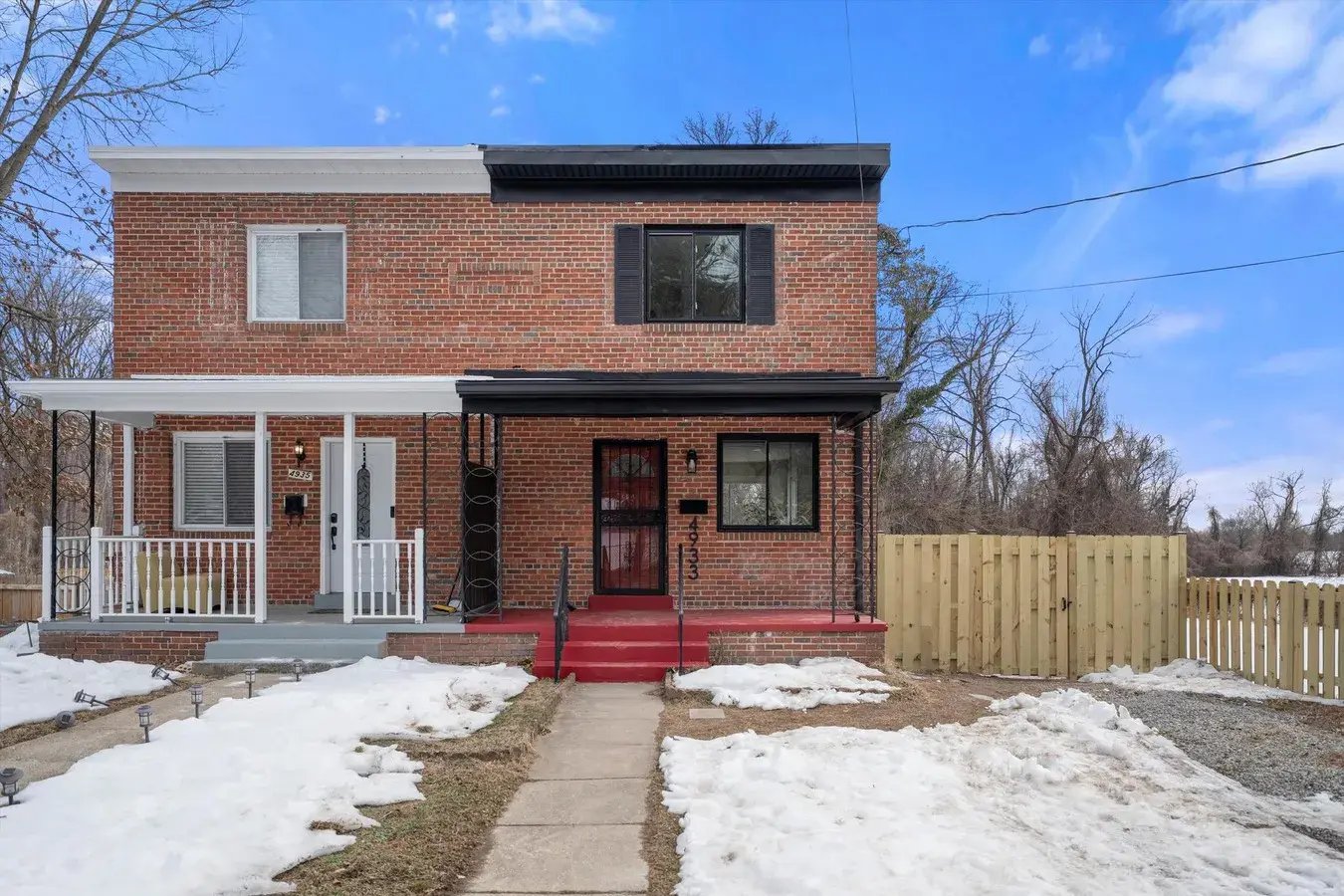 Renovated brick home with new porch roof, windows and wood fence